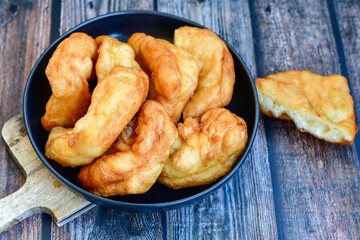 Traditional Bulgarian home made deep fried  patties  covered with sugar  оn rustic backgroud.Mekitsa or Mekica,  on wooden  rustic  background. Made of kneaded dough that is deep fried 