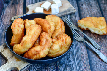 Traditional Bulgarian home made deep fried  patties  covered with sugar  оn rustic backgroud.Mekitsa or Mekica,  on wooden  rustic  background. Made of kneaded dough that is deep fried 