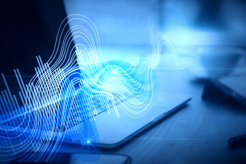 Close up of workspace with laptop computer and digital sound wave on blurry background. Technology,...