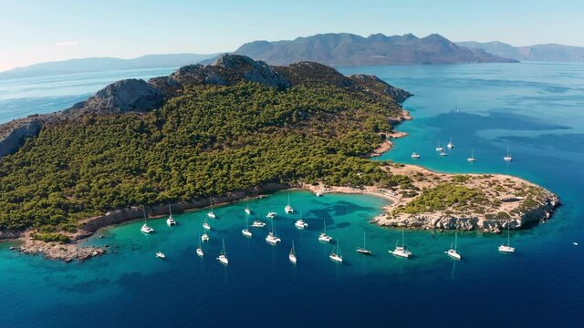 Yacht near the green island in Greece. Luxury vacation at sea.