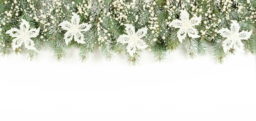 Christmas border in white colors. Long Christmas banner made of snow-covered blue spruce branches, white flowers and pearl beads. Festive banner in a gentle pastel style.