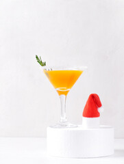Yellow cocktail in martini glass decorated with sugar border and rosemary. Christmas drink with...