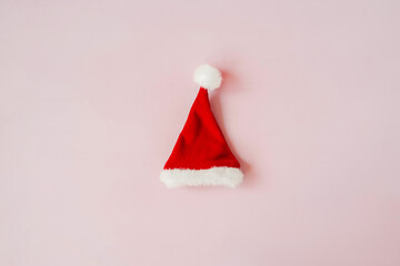 Red Christmas hat on pink background above.