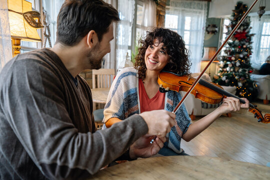 Private Male Music Teacher Giving Violin Lessons To A Woman At Home