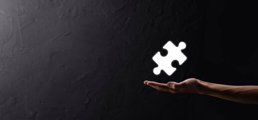 Businessman hands connecting puzzle pieces representing the merging of two companies or joint venture, partnership, Mergers and acquisition concept.