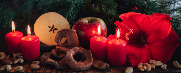 Christmas still life with winter apple and chocolate rings. Atmospheric background with red advent...