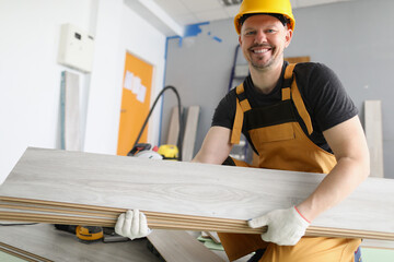 Professional carpenter carry wooden planks to apartments room