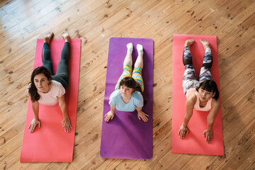 Young woman with down syndrome doing exercise during yoga group class