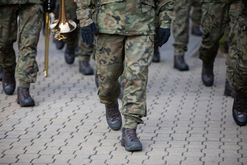 Soldiers on parade march with brass instruments.