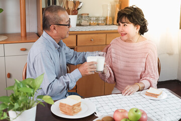 Portrait of happy couple senior asia woman and retirement man having breakfast together