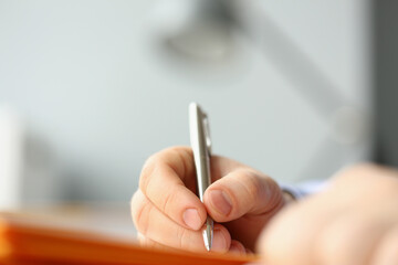 Professional businessman writing his idea in notebook with silver pen