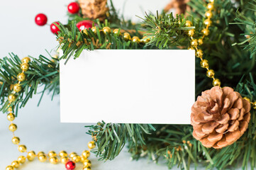 white confused card, next to a green spruce branch and Christmas decor