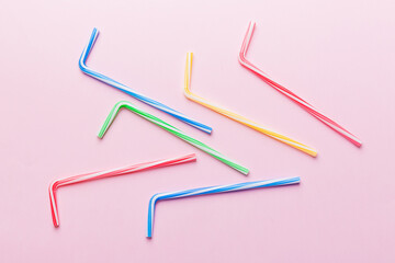 Drinking straws for party on Colored background. Top view of colorful plastic disposable straws for summer cocktails. different straws for juice with copy space