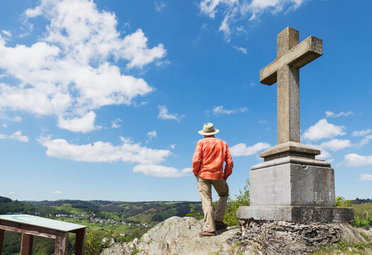Man by Summit Cross looking at Dedenborn, on sunny day, Simmerath, Eifel, North Rhine Westphalia, Germany