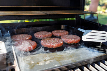 Meat with smoke on barbecue grill at backyard