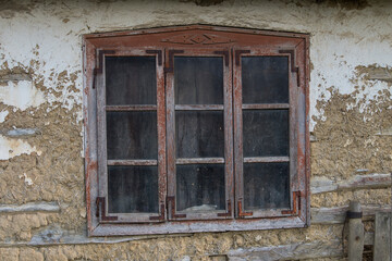 Fototapeta na wymiar Sunja,Croatia,05,04,2021. Rustic style aged window in wooden village rural home wall.