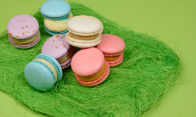 baked macarons with different flavors on a green background, top view