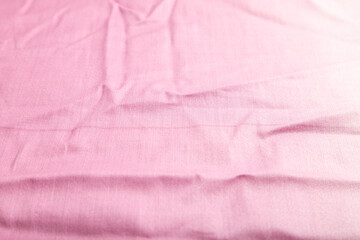 Fragment of smooth cotton purple tissue. Side view, natural textile background.