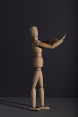 Wooden mannequin shows obscene gesture fuck off with hands on gray background. protest, riot,...