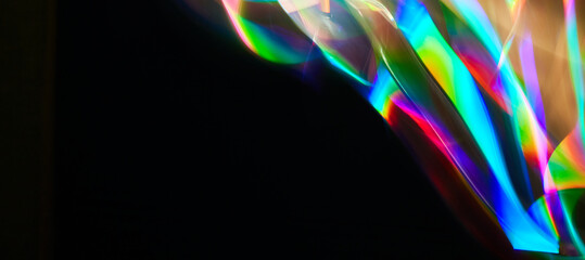 Blurred bright rainbow light. Lens or prism dynamic flare. Draving shiny spots. Dark background. Illuminated burst of multicolor light. - obrazy, fototapety, plakaty