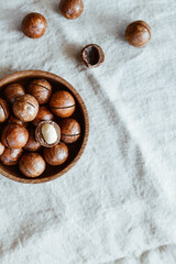 Top view of macadamia nuts in a wooden bowl on a table