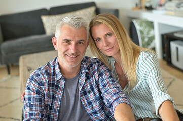 Portrait of middle-aged couple relaxing in sofa at home