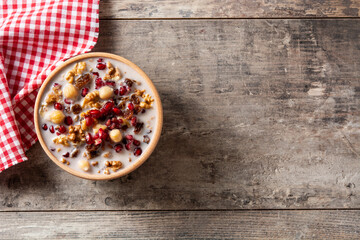 Traditional Turkish Noah's pudding in bowl on wooden table. Copy space