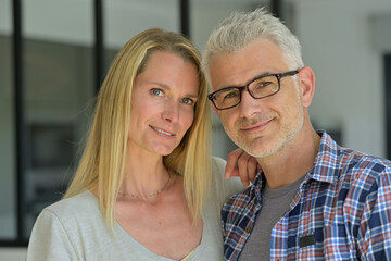 Portrait of middle-aged couple relaxing in sofa at home