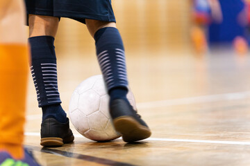 Indoor Football Training Session. Child Kicking Soccer Ball on Wooden Parquet Floor. Kids...
