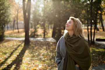 Smiling woman with eyes closed in autumn park