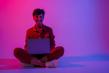 Mature european woman working with laptop while sitting on floor