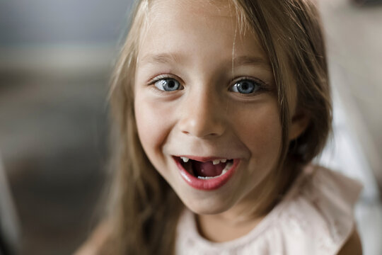 Girl smiling with gap tooth at home