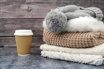 winter clothes. Sweater, scarf hat. A glass of coffee.