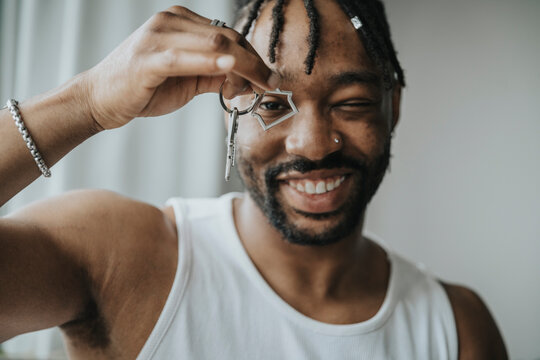 Smiling Man Looking Through House Shape Key Ring