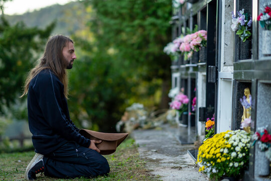 Man with hat praying at cemetery