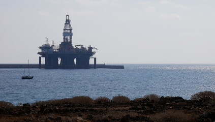 Plataforma petrolífera y barco velero