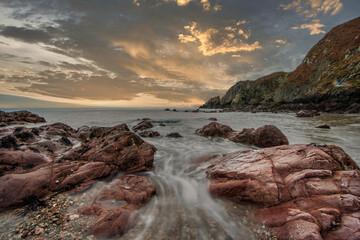 Fototapeta premium The Peninsula of Howth Head, Dublin, Dublin County, Seashore of cliffs, bays and rocks landscape, Ireland, hidden bay, dramatic sky, long time exposure