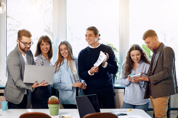 Team of office workers showing each other new ideas for the project.