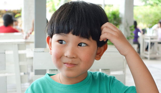 Cute Asian boy sitting in restaurant