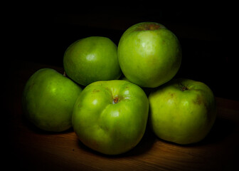 Bunch of five green apples (Granny Smith, Golden, Pippin, Crispin) isolated on a wooden table - Powered by Adobe