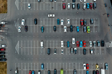 Cars are parked on asphalt parking with markings near the airport. Parking with lots of space is...