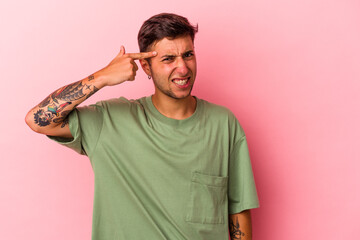 Young caucasian man with tattoos isolated on yellow background  showing a disappointment gesture...