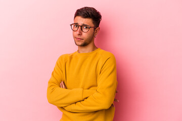 Young caucasian man with tattoos isolated on yellow background  suspicious, uncertain, examining you.