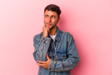 Fototapeta premium Young caucasian man with tattoos isolated on yellow background relaxed thinking about something looking at a copy space.