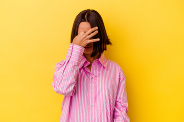 Young mixed race woman isolated on yellow background having a head ache, touching front of the face.