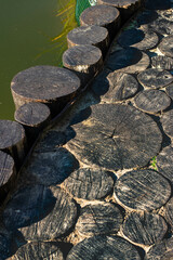 Fototapeta na wymiar edge of the pond bank lined with wood cuts
