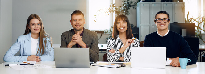 Happy business people are looking at the camera while smiling