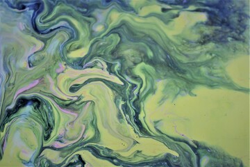 Abstract background of yellow-green marble. Multicolored spots of acrylic paint, freely flowing and creating an interesting pattern. Bright color. Background for the cover of a book, laptop.