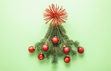 Christmas tree on green background. Fresh fir twigs and red baubles decoration. Merry Xmas card