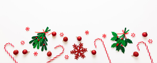 Christmas decoration border isolated on white background. Red balls and candy canes banner